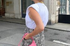 07 a bright summer look with a white top with accented shoulders, zebra print pants, a bold pink baguette bag