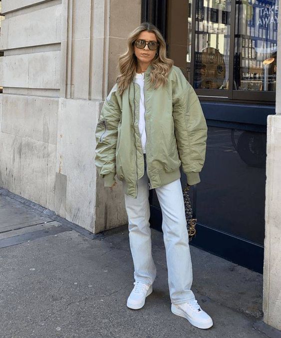a white t shirt, white jeans and sneakers, a light green bomber jacket and a bag with chain for spring