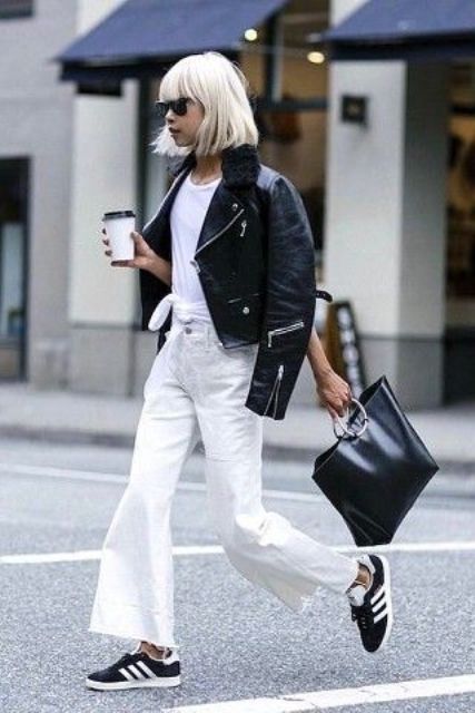 a black and white look with a white tied up t shirt, white jeans, a black leather jacket, a black tote and black Adidas sneakers