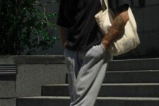 08 a sport look with a black t-shirt, grey sweatpants, white trainers and socks, a neutral canvas bag and a green cap