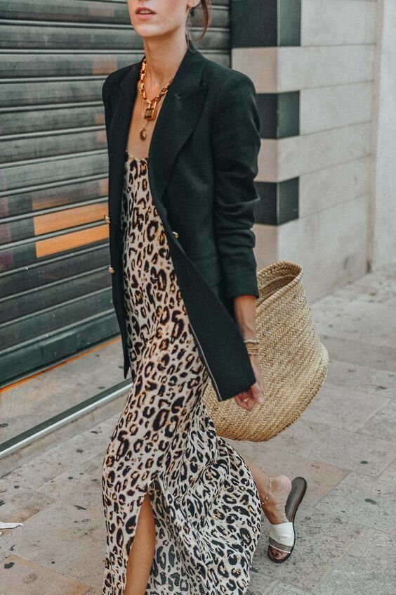a leopard print slip maxi dress, an oversized black blazer, white slippers, a statement necklace and a straw bag