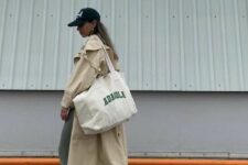 09 a sport chic outfit with green leggings, white socks, grey trainers, a beige maxi trench, a black cap and a neutral canvas bag
