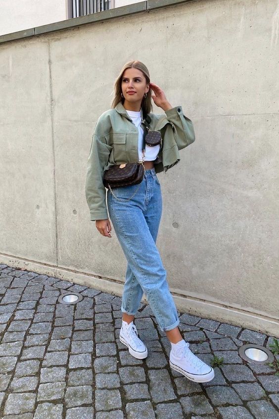 a white crop top, high waisted blue jeans, white sneakers, a green cropped jacket and a brown waist bag for spring