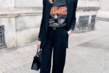 10 a black pantsuit, a printed t-shirt, a black bag and black high top sneakers are a cool and bold look