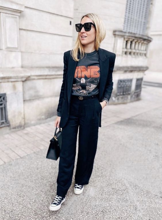 a black pantsuit, a printed t shirt, a black bag and black high top sneakers are a cool and bold look