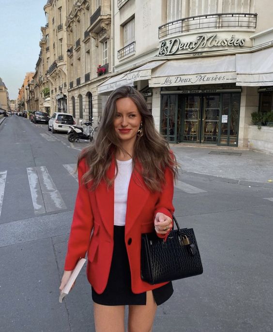 a simple and classy outfit with a white top, a black mini skirt with a slit, a red blazer and a black bag are a great combo for spring