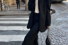 12 a black pantsuit with an oversized blazer, a white t-shirt, a chain necklace, white trainers and a black bag