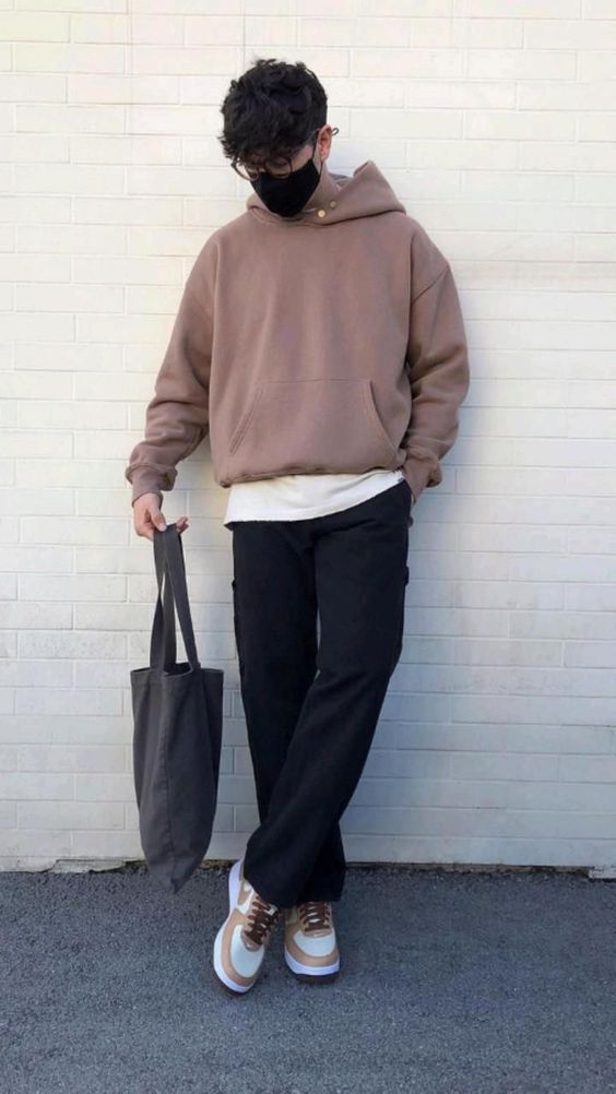 a white t-shirt, black cargo pants, a taupe hoodie, white and copper trainers and a grey canvas bag for a cold day