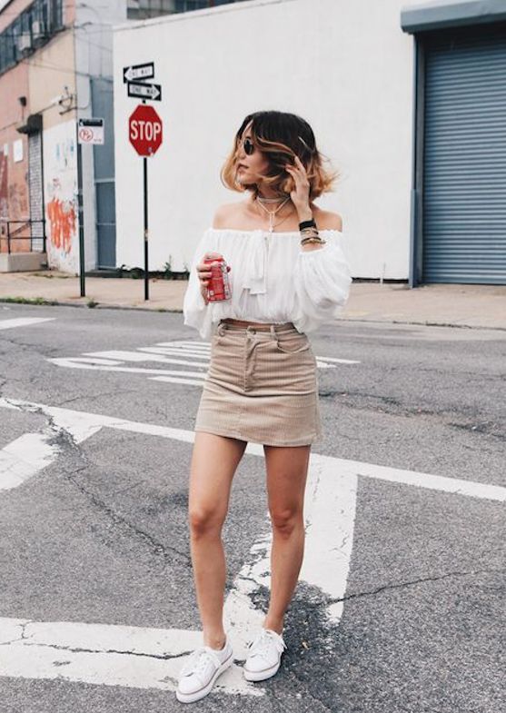 a sexy summer outfit with a white off the shoulder top, a tan denim mini, white sneakers