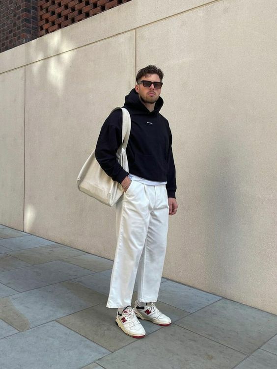 white trousers, a neutral tree, a black hoodie, neutral trainers and a neutral canvas bag for spring days