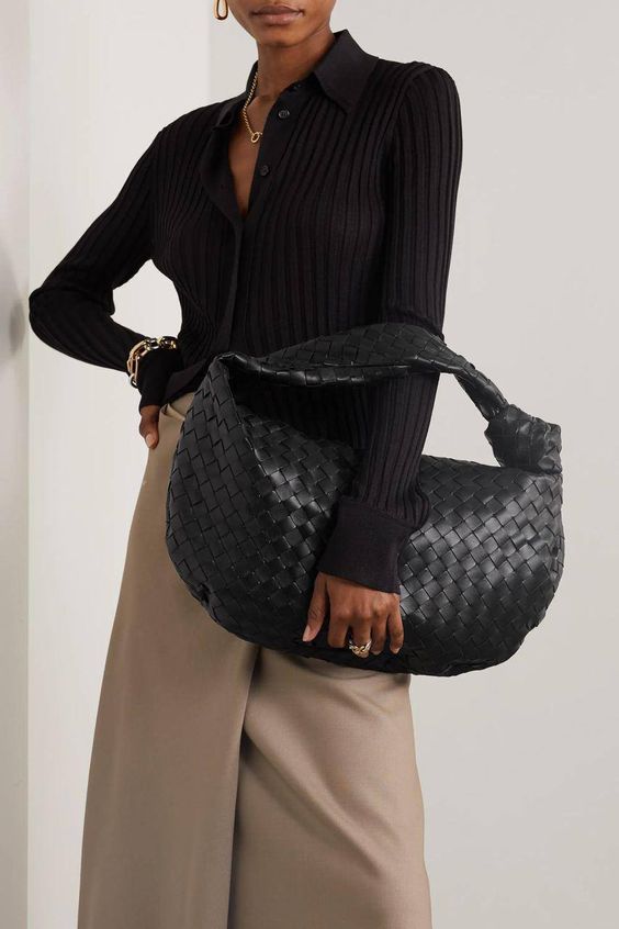a beige wrap midi skirt, a black jersey button up, a black woven hobo bag and elegant gold accessories