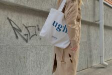 16 a beige trench, black jeans, a black cap, white sneakers, a white printed tote are a lovely look for spring
