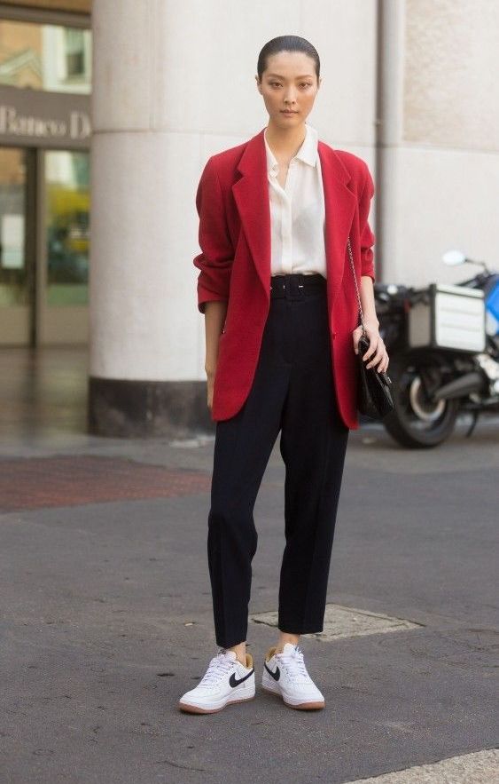 black trousers, a white button down, white sneakers, a red oversized blazer and a black bag for a casual work look