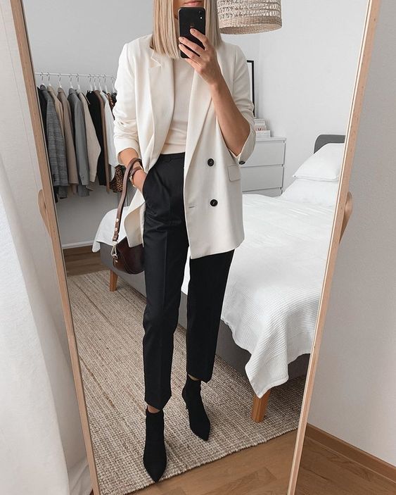 a monochromatic spring work look with a neutral top, a creamy oversized blazer, black pants, black sock boots and a brown bag