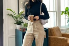 18 a black long sleeve crop top, tan jeans, black sneakers and a white baguette bag for spring