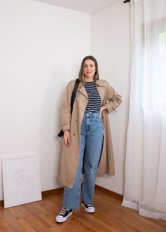 a Breton stripe top, blue jeans, black high top sneakers, a tan trench and a black bag are a comfortable spring look