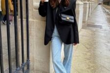 19 a casual outfit with a white t-shirt, blue flare jeans, black sneakers, an oversized black blazer and a black bag