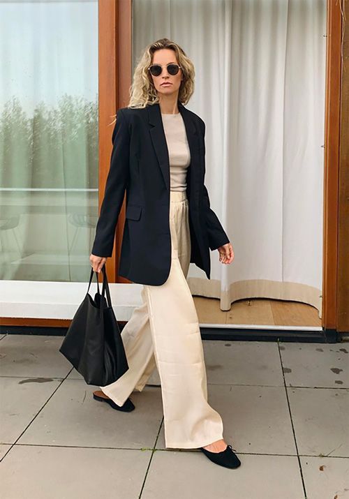 a grey t-shirt, tan wideleg trousers, black slippers, an oversized black blazer and a tote for work