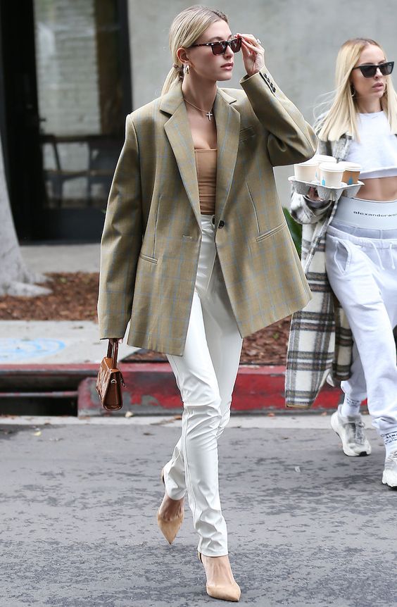 a tan top, white pants, tan shoes, an olive green oversized blazer and a brown mini bag for spring or summer