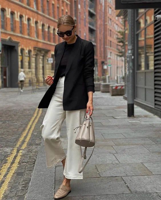 a minimalist work look with a black t-shirt and a blazer, white trousers, grey loafers, a grey bag is super cool