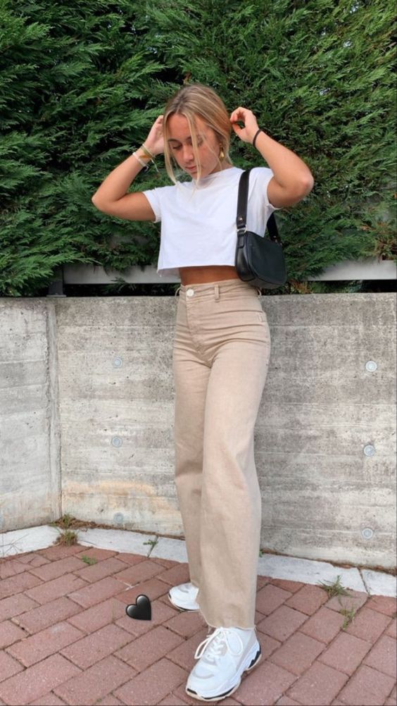 a white crop t-shirt, tan jeans, white trainers and a black baguette bag for summer