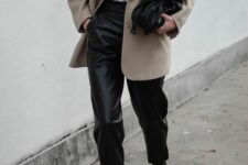 24 a white t-shirt, black leather pants, black boots, a greige oversized blazer and a black bag are a simple spring work look