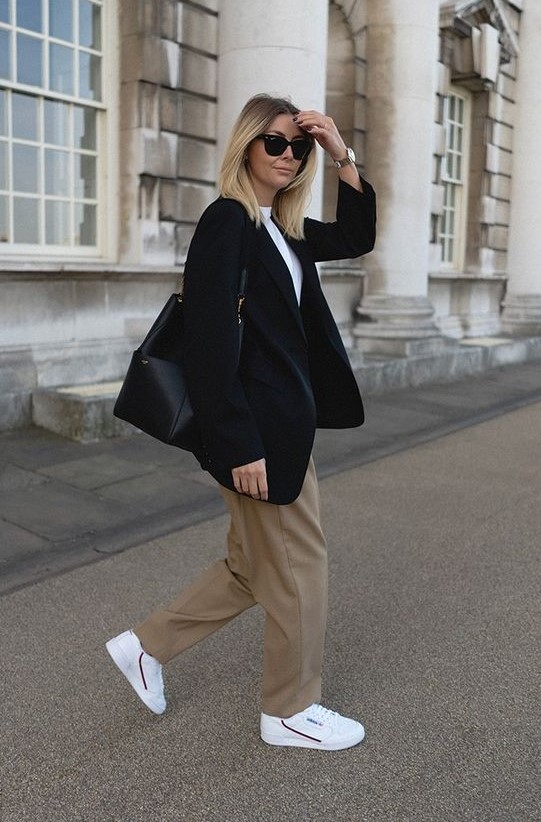 a smart casual look with a white shirt, taupe pants, white sneakers, an oversized black blazer and a bag, chic watch
