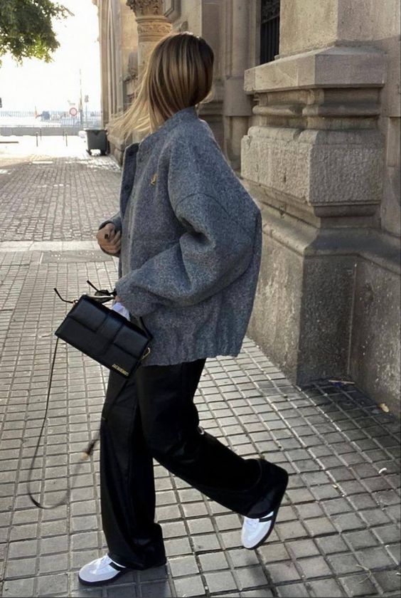 an oversized grey woolen bomber jacket, black pants, white Adidas sneakers, a small black bag for spring
