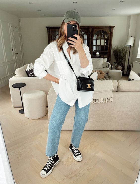 an oversized white t-shirt, blue jeans, black high top sneakers, a small black bag and a green cap are great for spring
