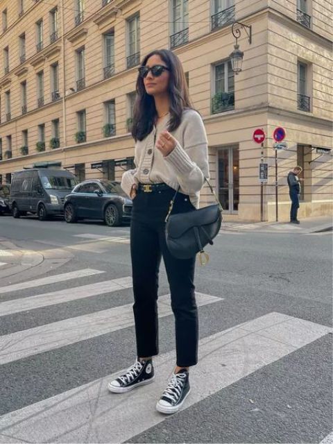 black cropped jeans, black high tops, a neutral cardigan tucked into jeans, a black saddle bag for a comfy every day look