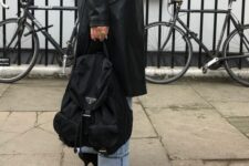 31 a 90s look with blue cuffed jeans, black heels, a black leather trench and a black backpack