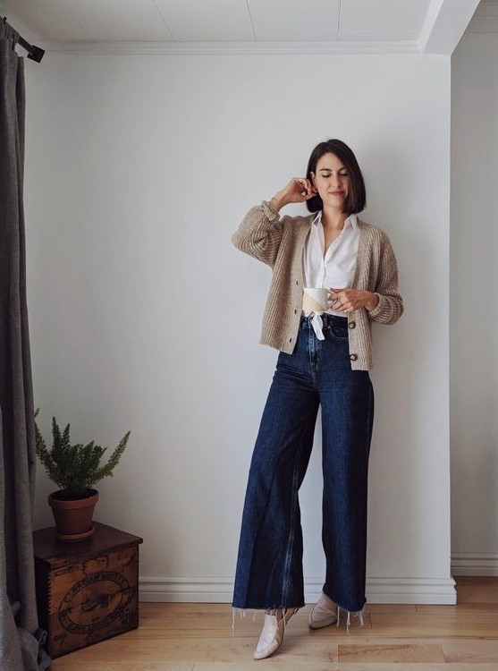 a white tied up shirt, a neutral cardigan, navy wide leg jeans, grey loafers are a lovely look that you may wear all the time
