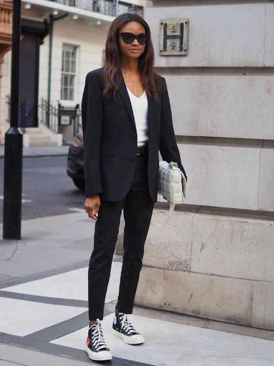 black jeans, a white top, an oversized black blazer, black sneakers and a white woven bag are a nice look for work
