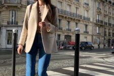 32 a brown t-shirt, a beige blazer, blue cropped jeans, tan boots and a brown bag for a Parisian chic outfit