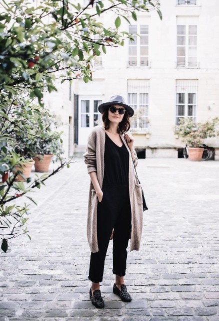With gray wide brim hat, sunglasses, black loose top, black leather bag and black and gray leopard printed flat shoes