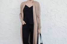 With oversized rounded sunglasses, black top, black leather tote bag and black flat shoes