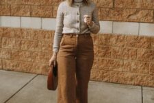 With rounded sunglasses, gray turtleneck, brown leather bag and brown leather flat ankle boots
