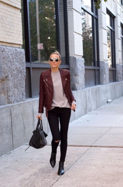 With sunglasses, pale pink loose t-shirt, black leather ankle boots and black leather bag