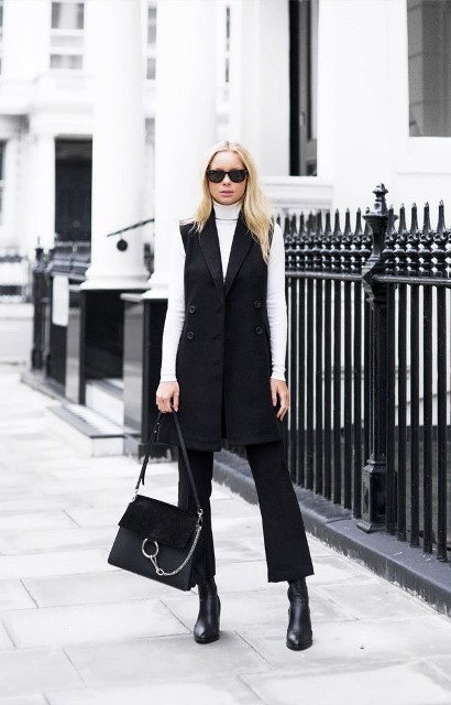 With sunglasses, white fitted turtleneck, black leather and suede bag and black leather mid calf boots