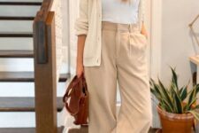 With white t-shirt, golden necklace, brown leather bag and white sneakers