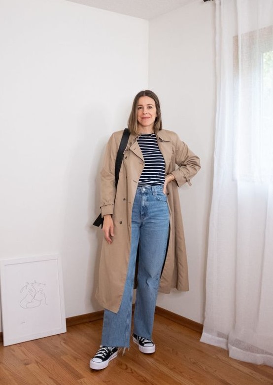 a Breton stripe top, blue jeans, black high top sneakers, a tan trench and a black bag are a comfortable spring look