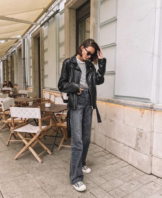a Breton stripe top, grey straight leg jeans, black sneakers, a black leather jacket and a black and white bag