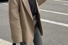 a black t-shirt, grey jeans, a beige oversized blazer, black sneakers, a small woven hobo bag and sunglasses