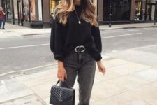 a monochromatic look with a black sweater, grey mom jeans, black booties, a black bag and a belt is chic
