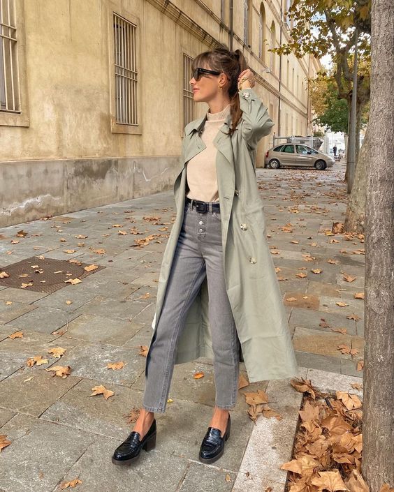 a neutral top, grey button down jeans, black loafers, a light green trench and a black belt compose a great look for spring or fall