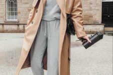 a sporty outfit with a grey tracksuit, black sneakers, a beige trench, a black cap and a black bag is very comfortable