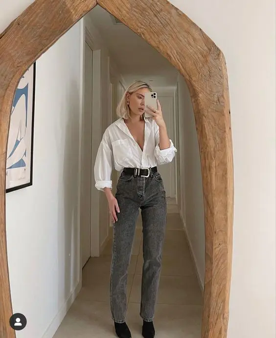 a white button down, grey high waisted jeans, a black belt and black boots are a chic and refined look for spring