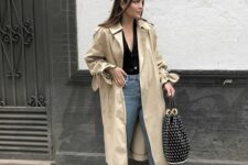 an elegant look with a black cardigan tucked into blue jeans, black mesh slingbacks, a beige trench and a black bag