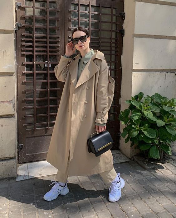 an olive green shirt, beige jeans, white trainers, a beige trench, a black bag are a stylish look for spring
