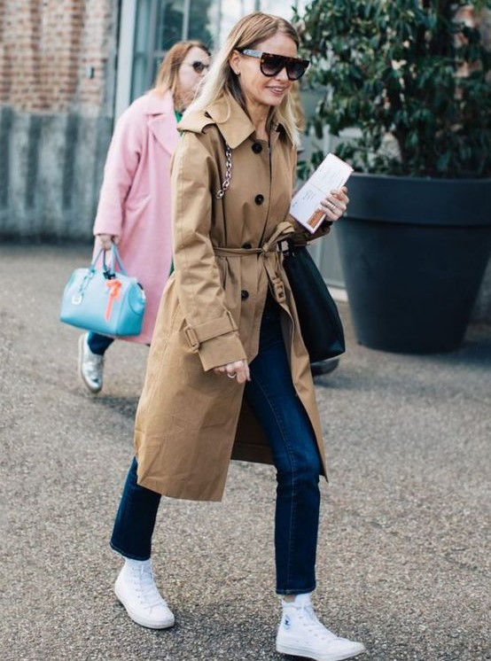 navy jeans, white high tops, a beige trench and a black bag are a great combo for spring